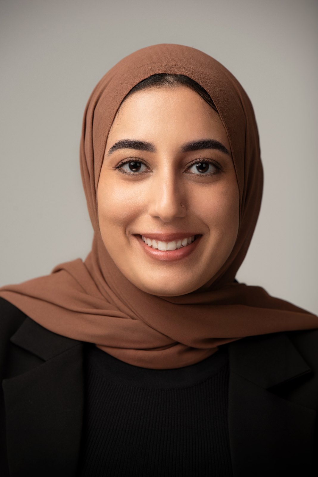 Zahra wearing a brown scarf and black blazer for an ERAS medical headshot at PhotoTale Studio in Gainesville, Florida.